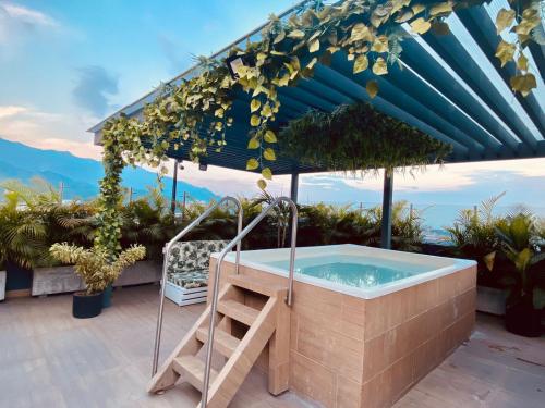 a hot tub on a patio with an umbrella at Hotel Doral Inn in Ibagué