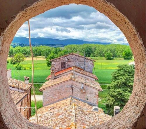 a round window of a building in a field at Dimora Storica Torre degli Arduini, San Giacomo, Spoleto in San Giacomo