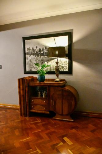 a room with a table with a lamp and a mirror at THE WHITE HOUSE in Johannesburg