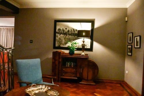 a living room with a chair and a table and a mirror at THE WHITE HOUSE in Johannesburg