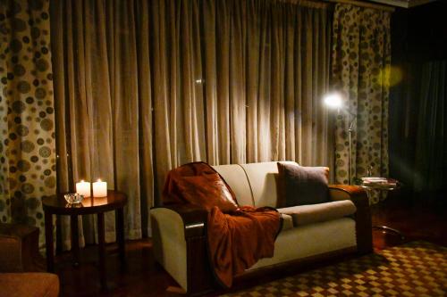 a living room with a couch and a table with candles at THE WHITE HOUSE in Johannesburg
