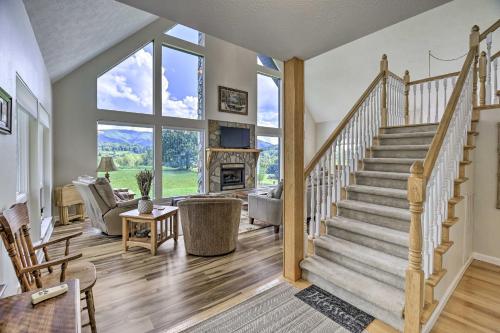 a living room with a staircase and a fireplace at Secluded Mountain City Home with Deck and Views! in Mountain City