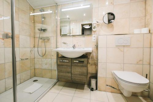 a bathroom with a toilet and a sink and a shower at Apartments Margarethenbad in Rangersdorf