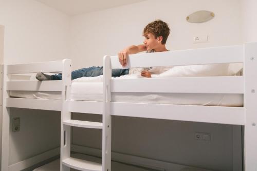 a young boy sitting on top of two bunk beds at Apartments Margarethenbad in Rangersdorf