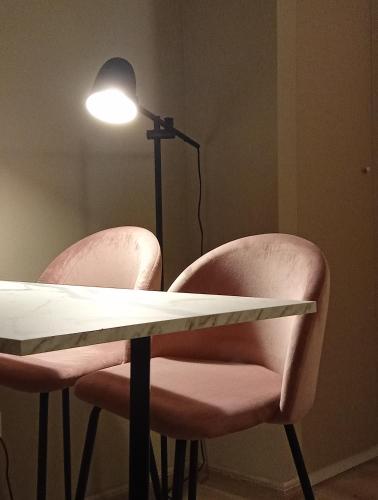 two pink chairs and a table with a lamp at Narciso boutique apartment in Acireale