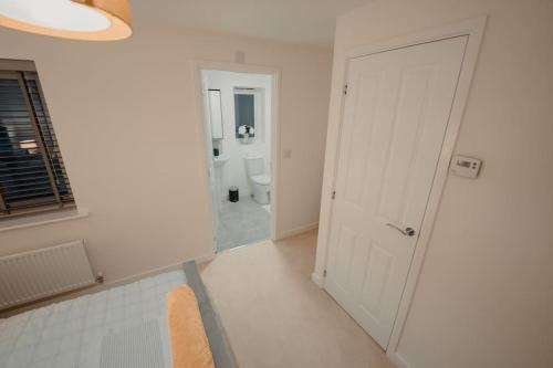 a bathroom with a toilet and a white door at Willow Heights Modern 5-7 Persons/3 Bed Detached in Rotherham