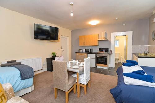 a living room with a bed and a dining room at The Elm Wood Apartments in Huddersfield