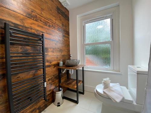 La salle de bains est pourvue de toilettes et d'une fenêtre. dans l'établissement De Parys Serviced Flat in Bedford 4, à Bedford