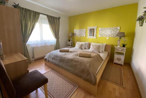 a bedroom with a large bed and a yellow wall at Villa СARPE DIEM in Laško
