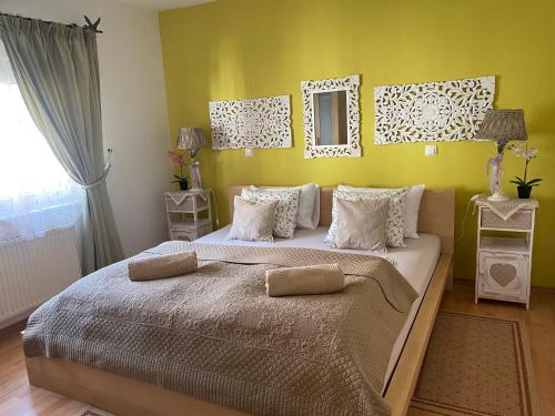 een slaapkamer met een groot bed met een gele muur bij Apartment BRIONI in Laško