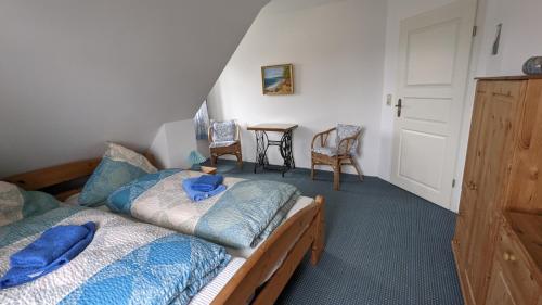 1 Schlafzimmer mit 2 Betten mit blauer Bettwäsche und Stühlen in der Unterkunft Ferienhaus Arkona Putgarten in Putgarten