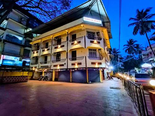 a hotel building with a parking lot at night at Sanman Hotels in Vasco Da Gama