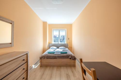 - une petite chambre avec un lit et une table dans l'établissement Apartament Gdańsk Stare Miasto przy Neptunie, à Gdańsk