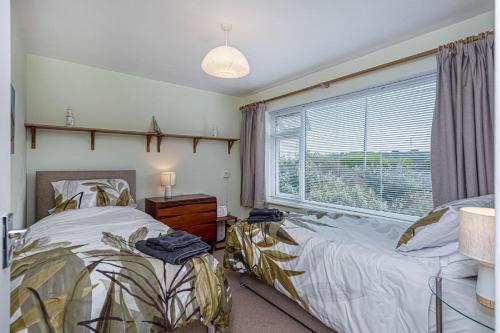 um quarto com 2 camas e uma janela em Lon Penrhyn em Benllech