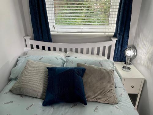 a bedroom with a bed with pillows and a window at Apartment 49, Ground floor, 2 Bedrooms with parking in Brean