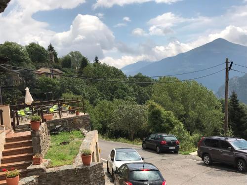 dois carros estacionados numa estrada com montanhas ao fundo em Charming Stone House in the Pre-Pyrennes em Ribes de Freser