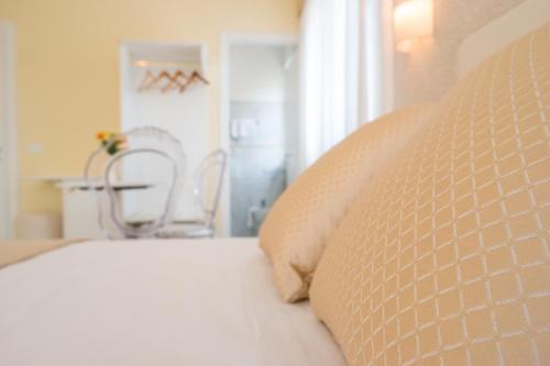 a bed with a pillow and a chair in a room at Guest House Train Station Venice - Atika & Atif in Mestre