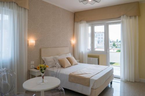 um quarto com uma cama, uma mesa e uma janela em Atika & Atif - Guest House Train Station Venice em Mestre