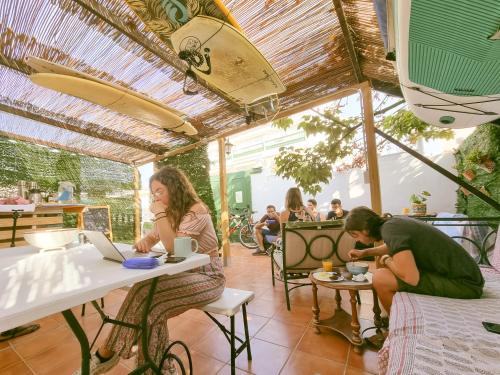 a woman sitting at a table in a restaurant at Arena Nest Hostel in Puerto de Santiago