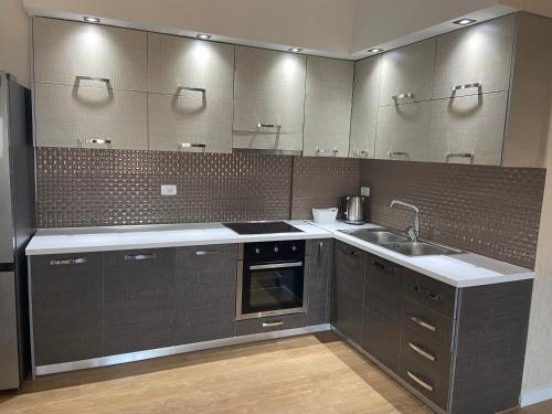 a kitchen with a sink and a stove top oven at MB luxury apartments in Tirana
