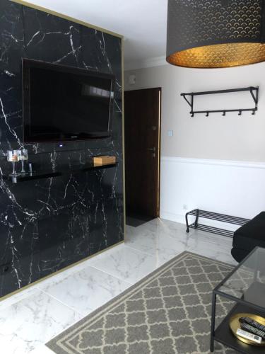 a living room with a black marble wall at Apartament Alicja in Sztutowo