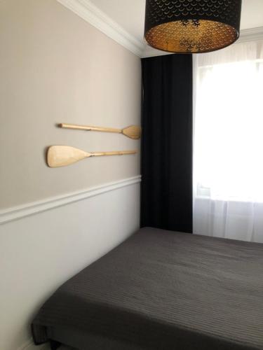 a bedroom with a bed with two wooden spoons on the wall at Apartament Alicja in Sztutowo