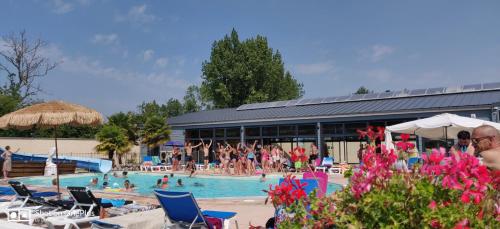 a swimming pool with a lot of people in it at Camping la Haie Penée **** in Saint-Quentin-en-Tourmont