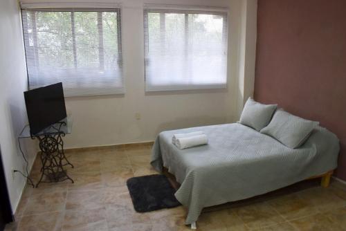 um quarto com uma cama e uma televisão em Casa Monarca em Oaxaca City