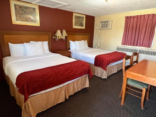 a hotel room with two beds and a table at Bestway Motel in Windsor