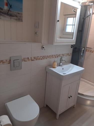 Waabs的住宿－Rosmarinchen，浴室配有白色卫生间和盥洗盆。