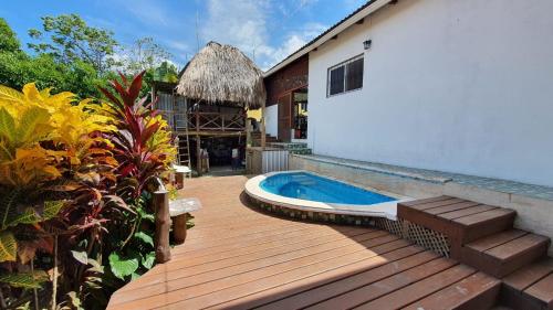 a wooden deck with a swimming pool next to a building at Hostal Blood Moon in Rio Dulce