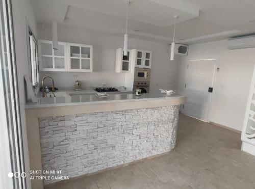 a kitchen with a brick counter in a room at Villa La Palmeraie d'Arkou, grande piscine in Arkou