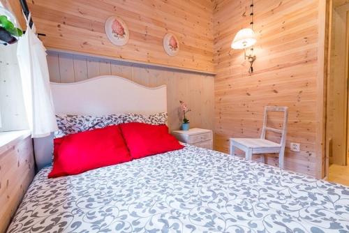 a bedroom with a large bed and a chair at Zagroda Dębki in Dębki