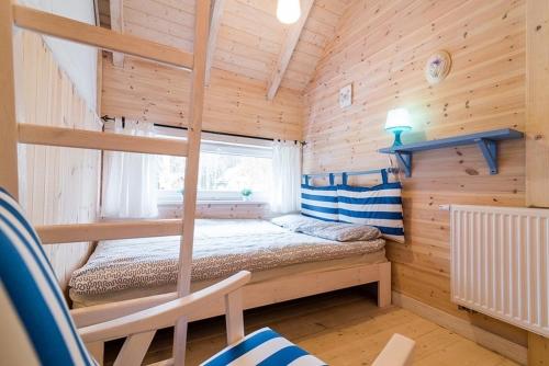 a bedroom with two bunk beds in a wooden cabin at Zagroda Dębki in Dębki