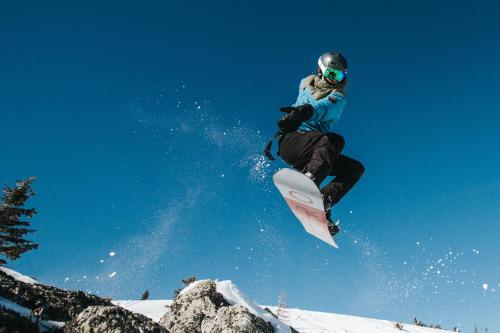 a person jumping in the air on a snowboard at Rtanj Kopaonik Eco Resort & Spa in Kopaonik