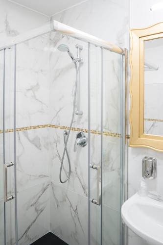 a shower in a bathroom with white marble walls at Guest House Train Station Venice - Atika & Atif in Mestre