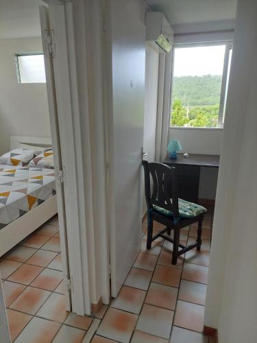 a bedroom with a chair and a desk and a window at Mabouya in Le Vauclin