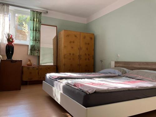Schlafzimmer mit einem Bett und einem Holzschrank in der Unterkunft DOMOV-VINA Holiday Apartment in Znojmo