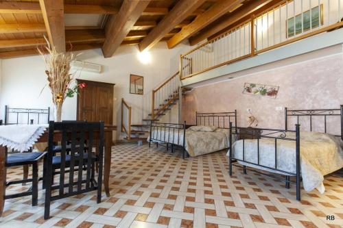 a room with three beds and a table and a dining room at Affittacamere Cà Marcello in Monselice