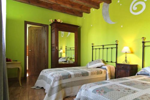 a green bedroom with two beds and a mirror at La Cantarilla 258 in Aldehuela del Rincón