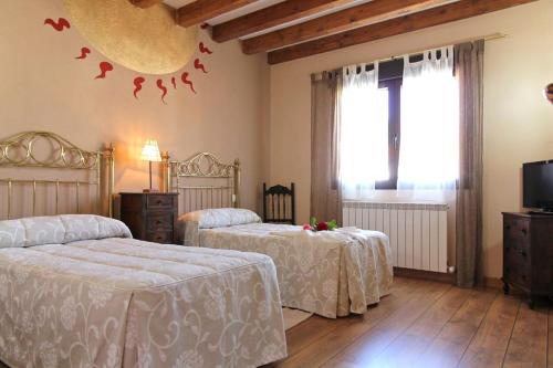 a bedroom with two beds and birds on the wall at La Cantarilla 258 in Aldehuela del Rincón