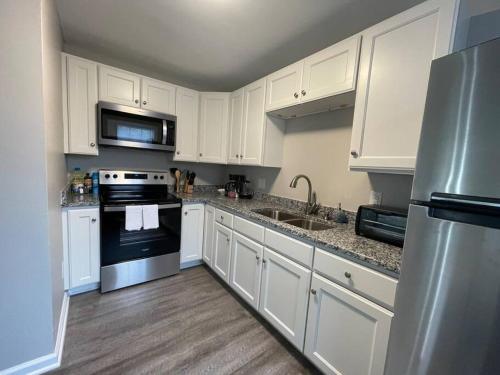 a kitchen with white cabinets and a stainless steel appliances at * Prime Place * Pet Friendly * King Bed * in Durham