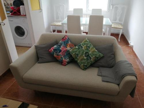 un sofá con almohadas en la sala de estar en La Pequeña Cercona, en La Granja de San Ildefonso