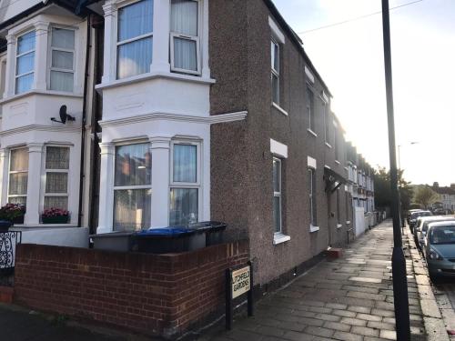 a brick building with white windows on a street at WIllesden Lodge Guest House in London