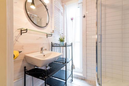 a bathroom with a sink and a mirror at Zagroda Dębki in Dębki