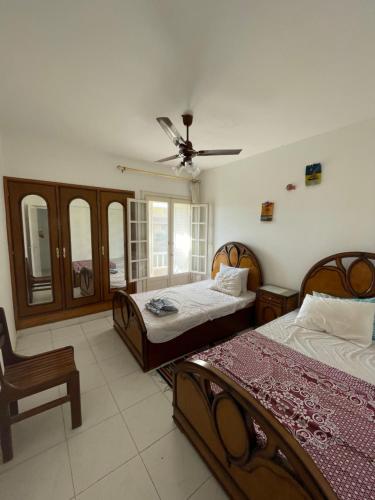 um quarto com 2 camas e uma ventoinha de tecto em 52H Green leaves Village, families & couples only em Dawwār Abū Duray‘ah ‘Abd al Karīm