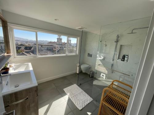 a bathroom with a sink and a shower with a window at Beautiful 3 Bed 3 Bath upper house in Bernal Glen in San Francisco