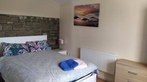 Un dormitorio con una cama con una toalla azul. en Lovely cosy cottage close to Atlantic beaches en Dromore West