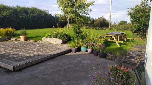 a garden with a picnic table and some plants at Lovely cosy cottage close to Atlantic beaches in Dromore West