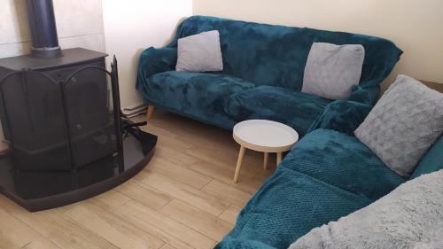 a living room with a green couch and a stove at Lovely cosy cottage close to Atlantic beaches in Dromore West